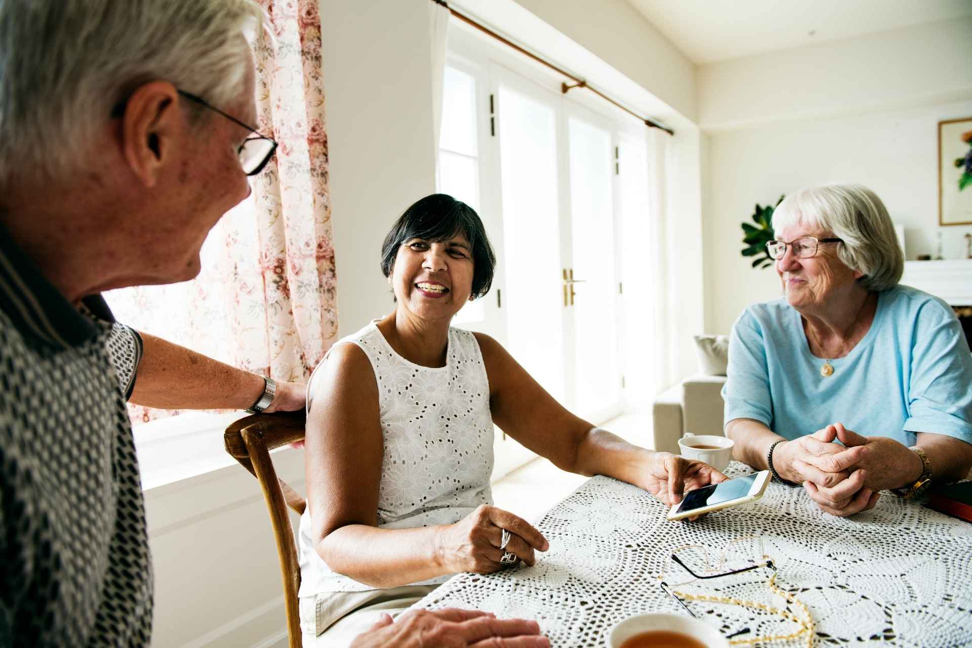 A group of seniors smiling and sitting at a table.